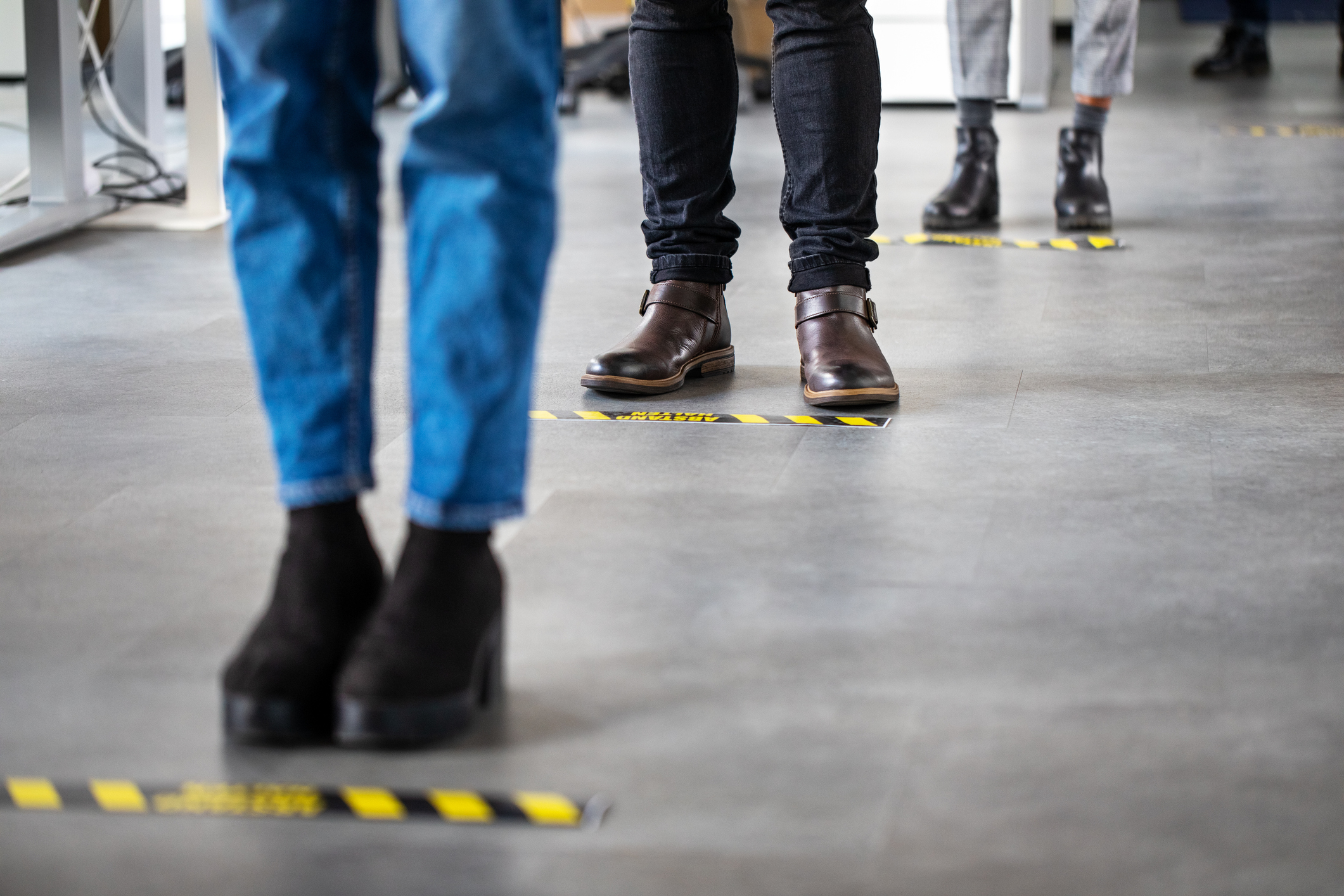 Standing behind social distancing signage on office floor